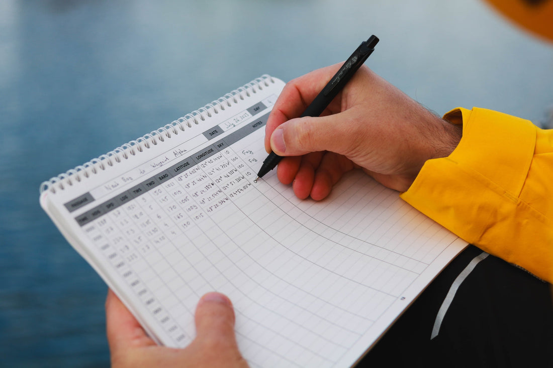 Person writing an entry in the marine sailing logbook