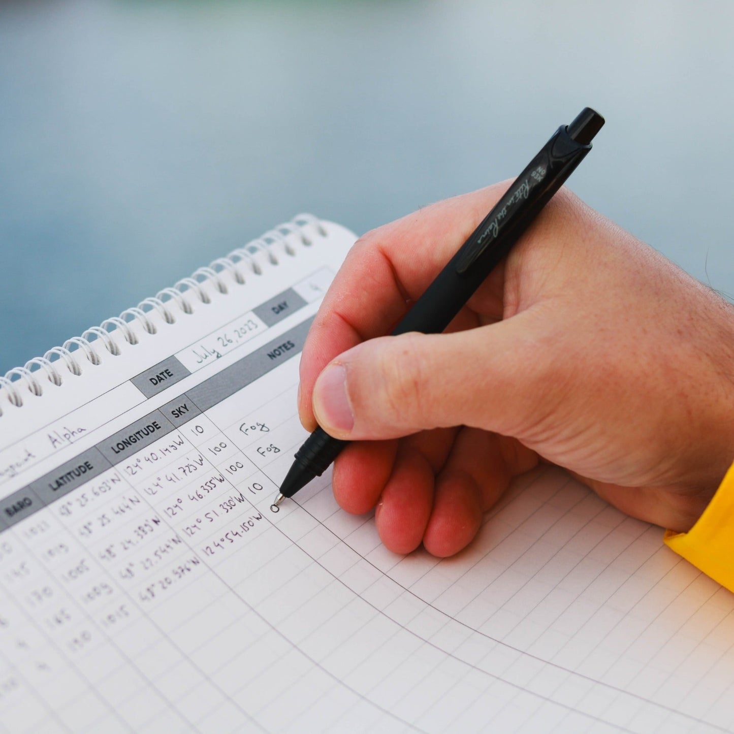 Photo: Sailor writing in waterproof offshore sailing log
