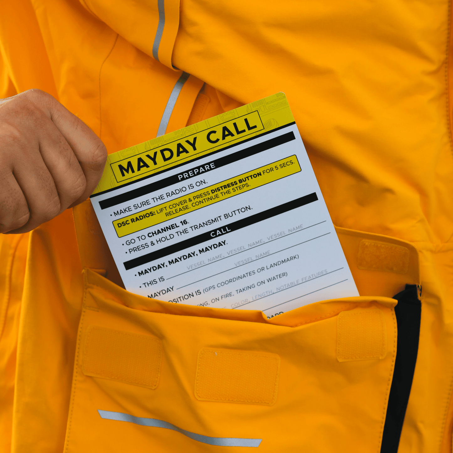 Boat safety reference card kept inside yellow foul weather gear for offshore sailing emergencies.