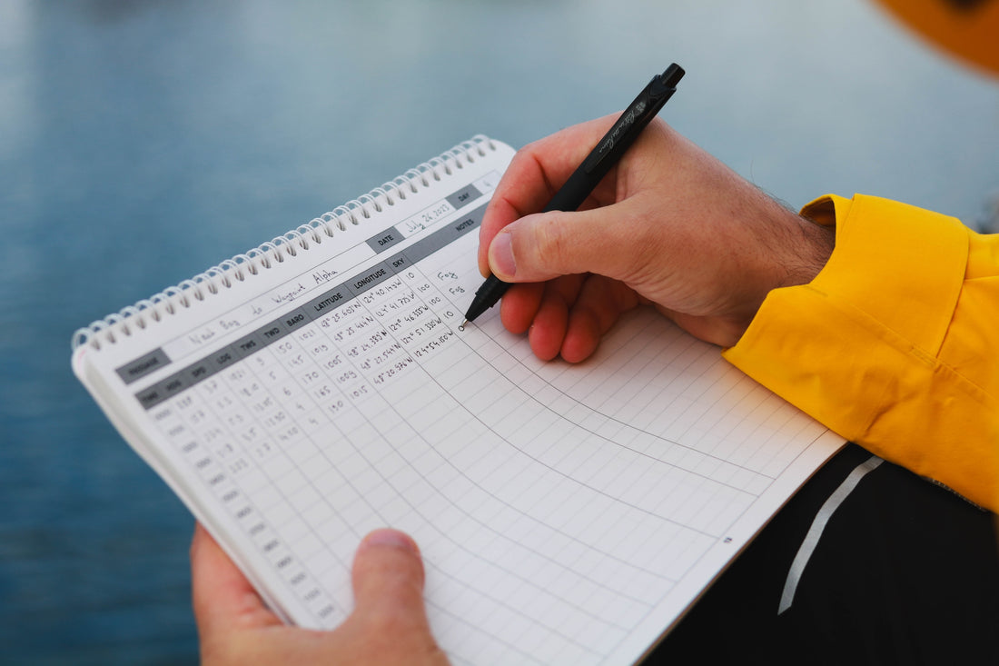Person writing an entry in the marine cruising logbook