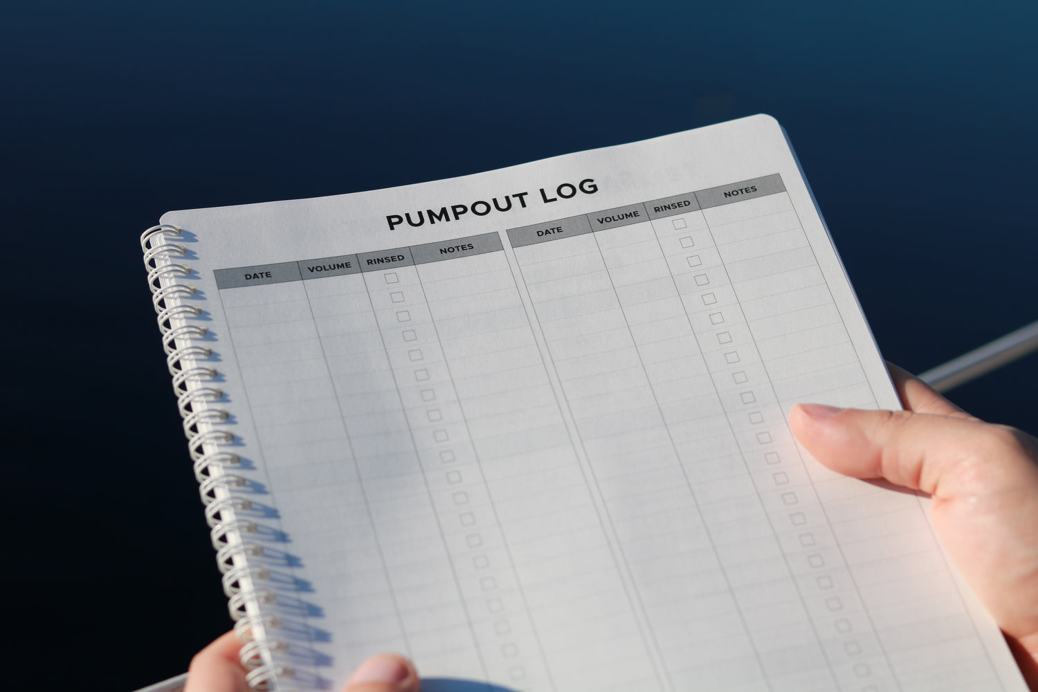 Sailor holding a 'pumpout log' page from All-weather Sailing Logbook