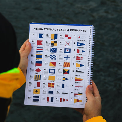 International maritime signal flags and pennants reference chart inside waterproof sailing logbook.