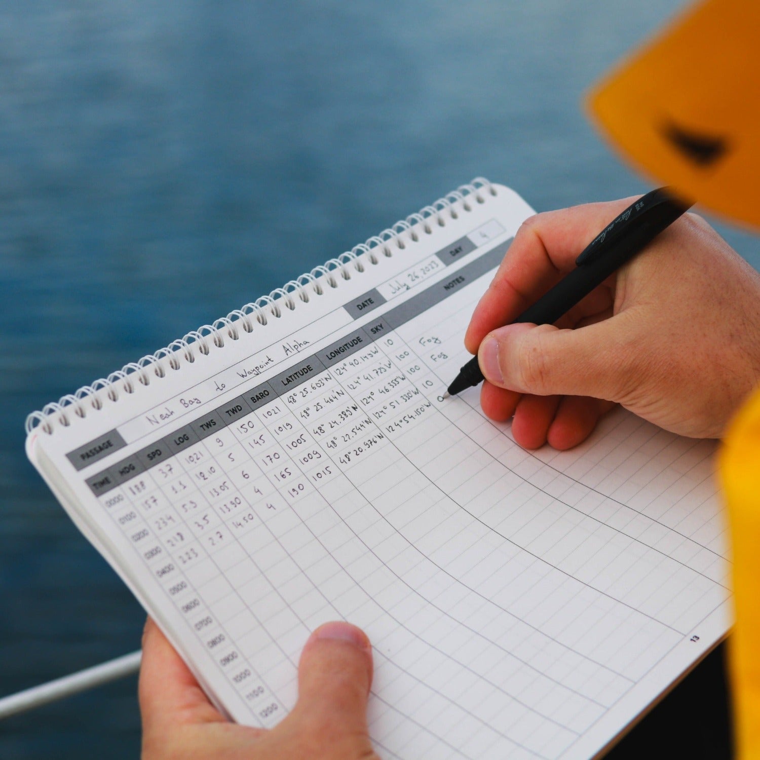 Photo: Mariner writing in offshore sailing logbook
