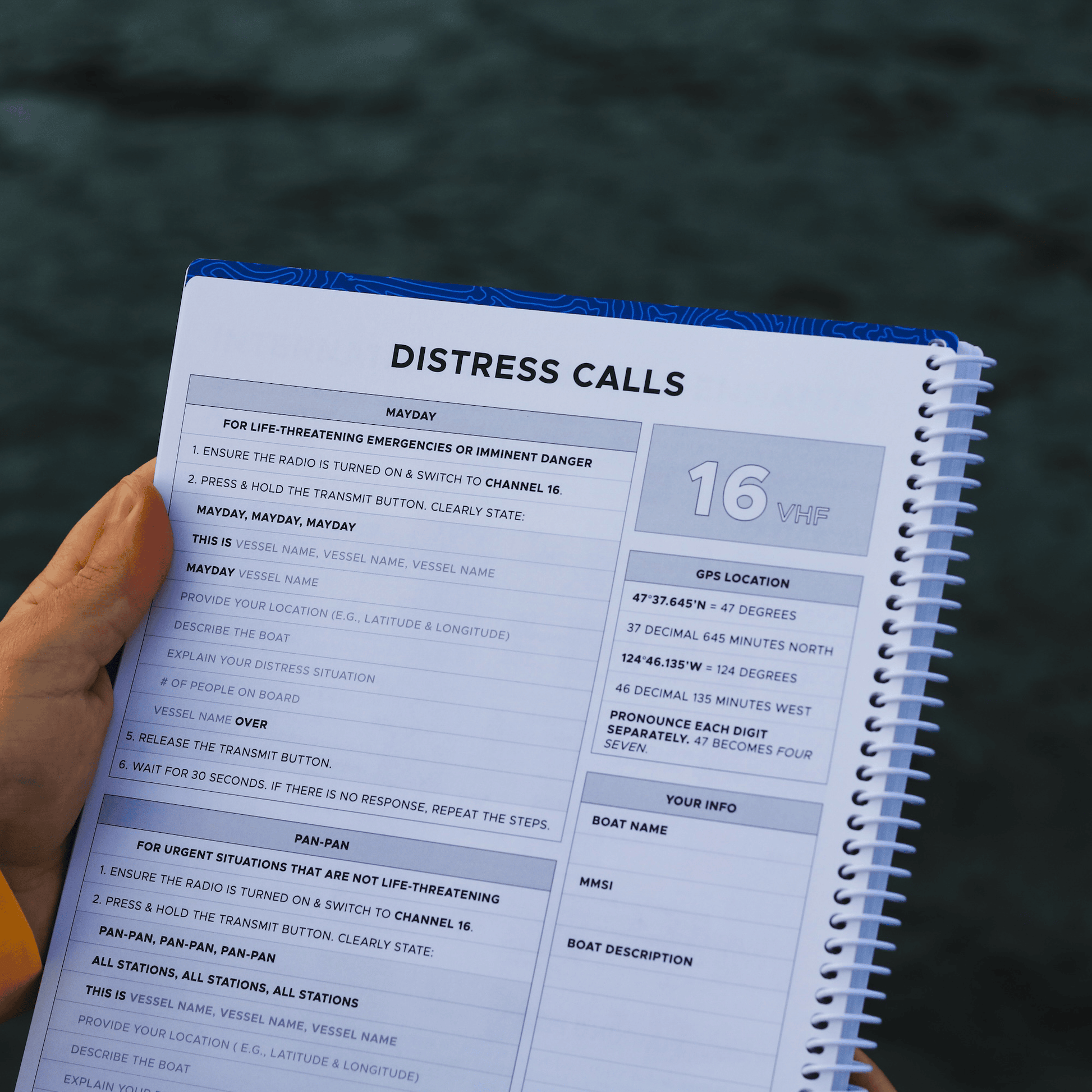 Mayday and Pan-Pan VHF Channel 16 distress call instructions page inside marine cruising logbook.