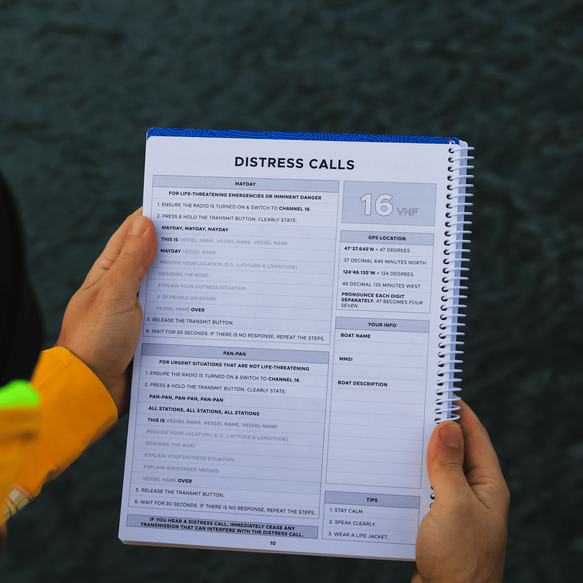 Mayday and Pan-Pan VHF Channel 16 distress call instructions page inside marine cruising logbook.