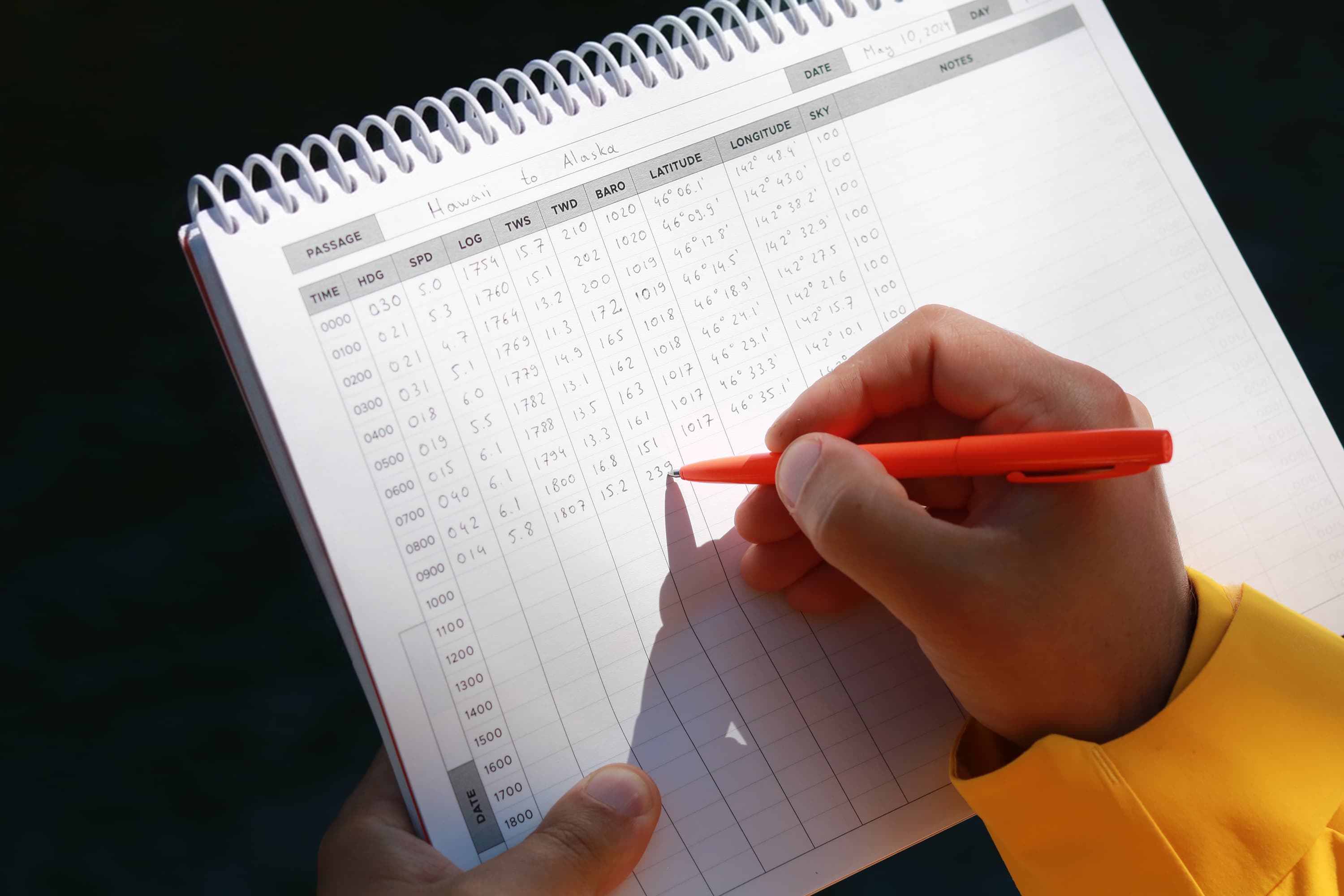 A sailor logging the data in the Offshore Sailing Logbook.